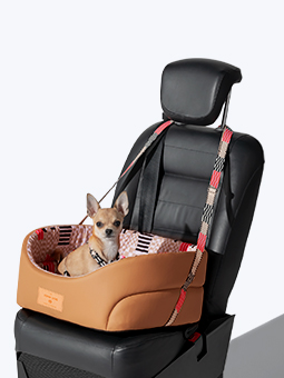 Ein kleiner Hund sitzt in einem Hundeautositz aus der John Dog Paris Kollektion