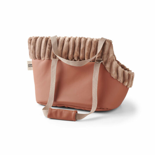 Hundetasche in Braun mit Fellbesatz und Griffen in Beige, Seitenansicht, mit John Dog-Logo auf dem Anhänger.
