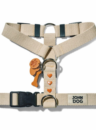 Beigefarbenes Hundegeschirr aus Baumwollgurtband aus der MANIFEST Kollektion von John Dog. Das Geschirr hat einen Schlüsselring aus Leder mit einem Knochen, einer Hundepfote und einem Herz sowie Nieten in Form von braunen Herzen.
