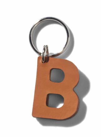 Brauner Schlüsselanhänger in Lederform aus der MANIFEST-Kollektion von John Dog. Der Schlüsselanhänger kann als Initialen für den Namen deines Hundes verwendet werden. Ideal als Dekoration für die Accessoires deines Hundes oder als stilvolle Dekoration für die Tasche deines Hundes.