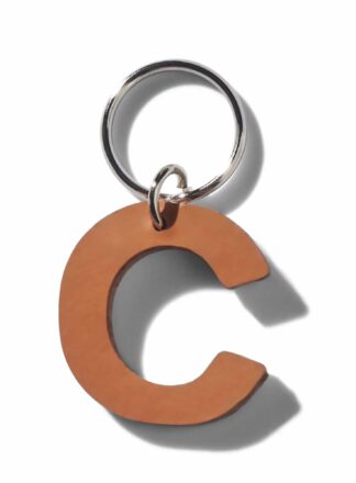 Brauner Lederschlüsselanhänger für Leine, Geschirr oder Halsband in Form des Buchstabens "C" aus der MANIFEST Kollektion von John Dog. Der Schlüsselanhänger kann als Initiale für den Namen deines Hundes verwendet werden.