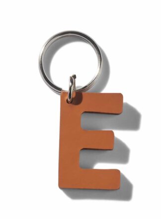 Brauner Schlüsselanhänger aus Leder in Form eines "E" aus der MANIFEST Kollektion von John Dog. Der Schlüsselanhänger kann als Initialen für den Namen deines Hundes verwendet werden. Ideal als Dekoration für die Accessoires deines Hundes oder als stilvolle Dekoration für die Tasche deines Hundes.