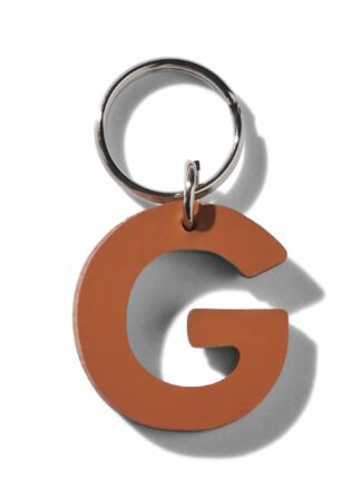 Brauner Lederschlüsselanhänger für Leine, Geschirr oder Halsband in Form des Buchstabens "G" aus der MANIFEST Kollektion von John Dog. Der Schlüsselanhänger kann als Initiale für den Namen deines Hundes verwendet werden.