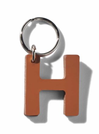 Brauner H-förmiger Schlüsselanhänger aus Leder für Leine, Geschirr oder Halsband aus der MANIFEST Kollektion von John Dog. Der Schlüsselanhänger kann für die Initialen deines Hundes verwendet werden.