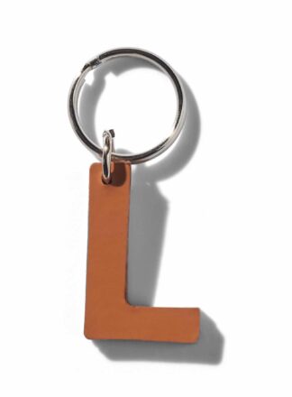 Brauner L-förmiger Schlüsselanhänger aus Leder für Leine, Geschirr oder Halsband aus der MANIFEST Kollektion von John Dog. Der Schlüsselanhänger kann für die Initialen deines Hundes verwendet werden.