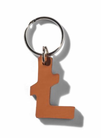 Brauner Leder-Schlüsselanhänger in Form eines £ aus der MANIFEST-Kollektion von John Dog. Der Schlüsselanhänger kann als Initialen für den Namen deines Hundes verwendet werden. Ideal als Dekoration für die Accessoires deines Hundes oder als stilvolle Dekoration für die Tasche deines Hundes.
