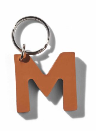 Brauner Lederschlüsselanhänger für Leine, Geschirr oder Halsband in Form des Buchstabens "M" aus der MANIFEST Kollektion von John Dog. Der Schlüsselanhänger kann als Initiale für den Namen deines Hundes verwendet werden.