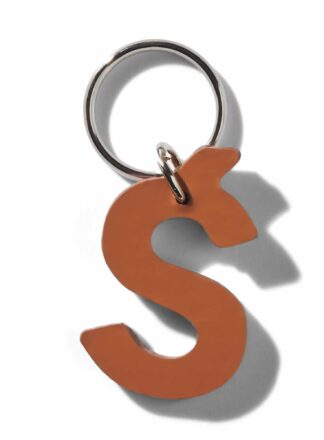 Brauner Lederschlüsselanhänger für Leine, Geschirr oder Halsband in Form des Buchstabens "¶" aus der MANIFEST-Kollektion von John Dog. Der Schlüsselanhänger kann als Initialen für den Namen deines Hundes verwendet werden.