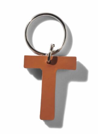 Brauner Lederschlüsselanhänger für Leine, Geschirr oder Halsband in Form des Buchstabens "T" aus der MANIFEST Kollektion von John Dog. Der Schlüsselanhänger kann als Initiale für den Namen deines Hundes verwendet werden.